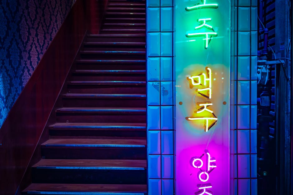 Colorful neon sign on a staircase in Seoul reflects nightlife and vibrant atmosphere.